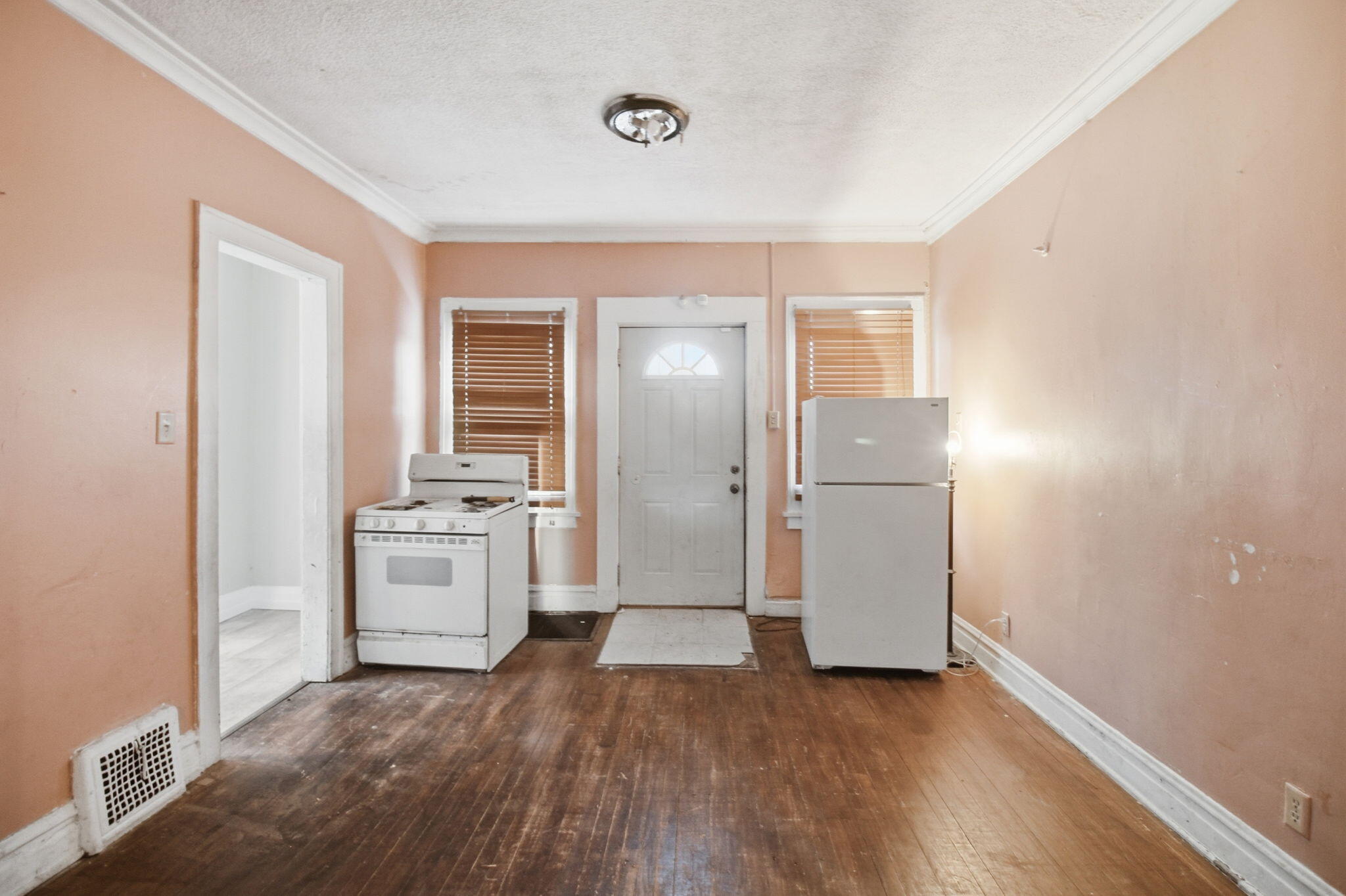 4427 Washington Street Gary, IN 46408 - Photo 4 of 9 an empty room with wooden floor and kitchen view