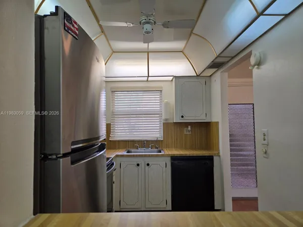 a kitchen with stainless steel appliances white cabinets white stove a refrigerator and a microwave