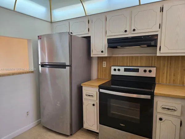 a kitchen with stainless steel appliances granite countertop a sink dishwasher a stove and a refrigerator
