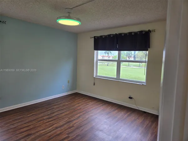 a view of a room with wooden floor and window