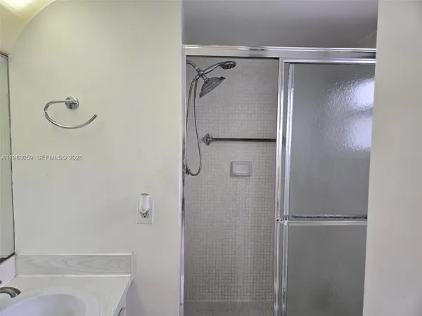 a bathroom with a sink a mirror and shower