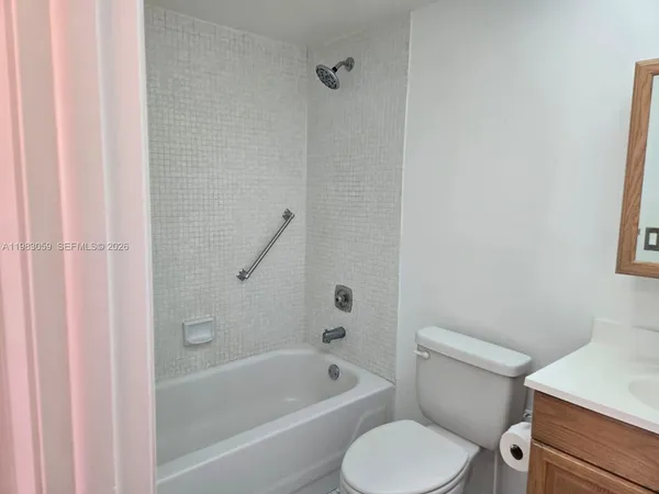 a white toilet and tub sitting next to a bathroom sink