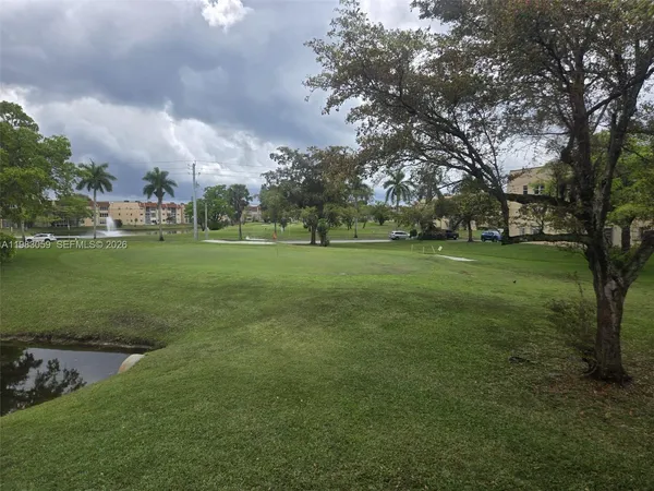 a view of a tennis ground with large trees