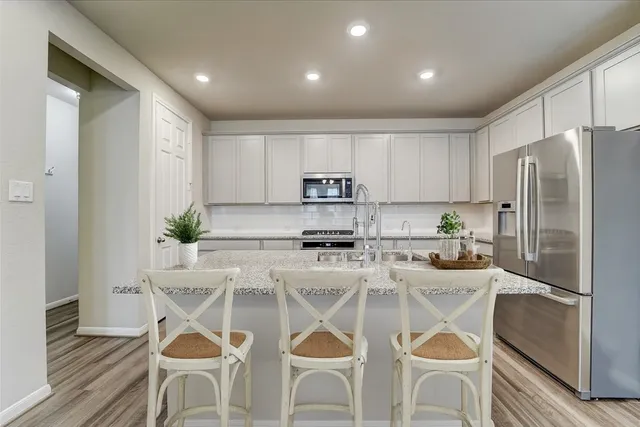 a kitchen with white cabinets and stainless steel appliances