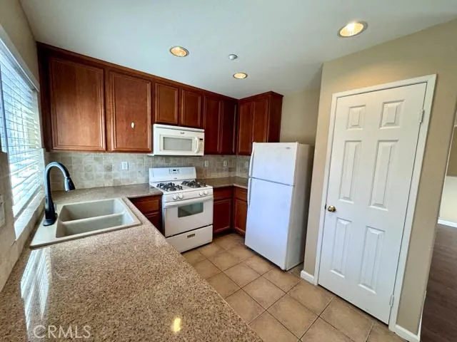 a kitchen with stainless steel appliances granite countertop a refrigerator sink and stove