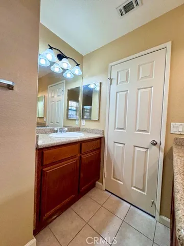 a spacious bathroom with a granite countertop sink and a mirror