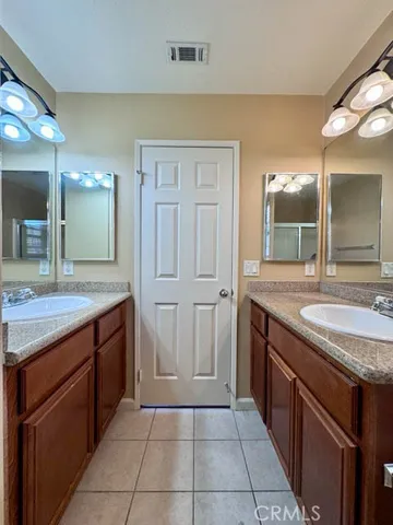 a spacious bathroom with a granite countertop sink and a mirror