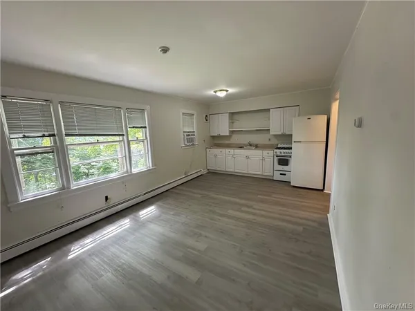 a view of a kitchen with wooden floor and electronic appliances