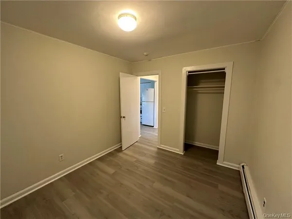 an empty room with wooden floor and closet
