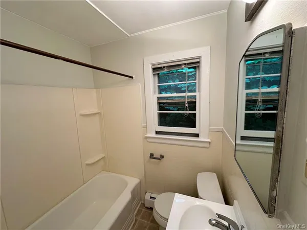 a bathroom with a sink a window and a toilet