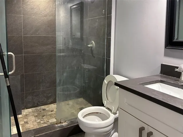 a bathroom with a granite countertop double vanity sink and mirror