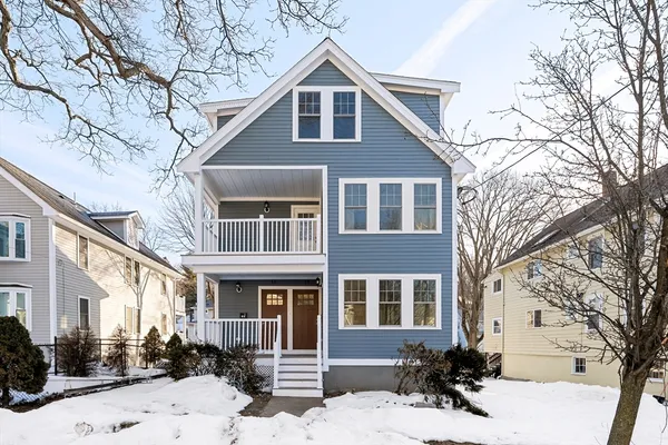 a front view of a house with a yard covered in snow