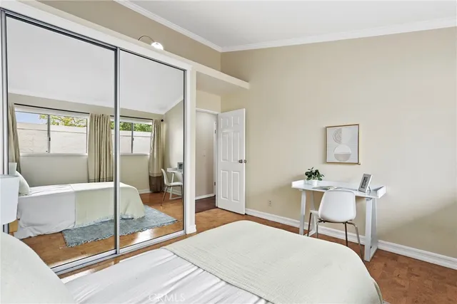 a bedroom with a balcony a bed and glass door