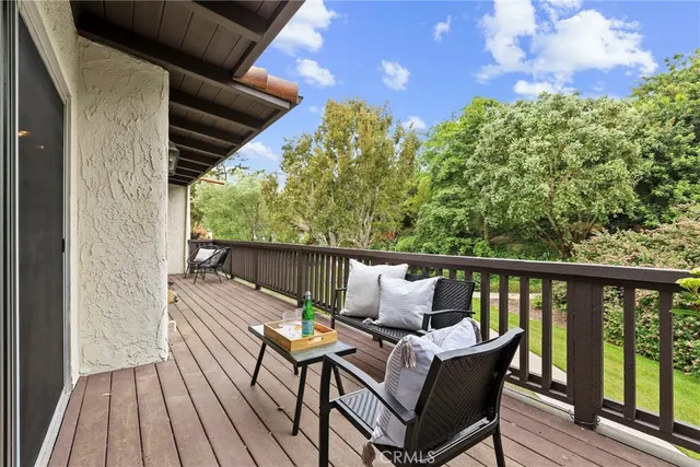a balcony with wooden floor and outdoor seating