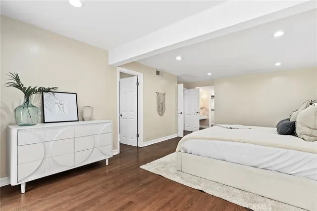 a spacious bedroom with a bed and a wooden floor