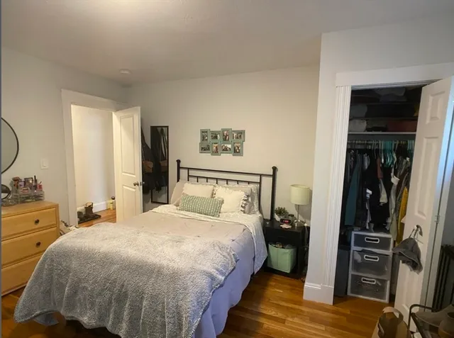 a bedroom with a bed and a flat tv screen on dresser