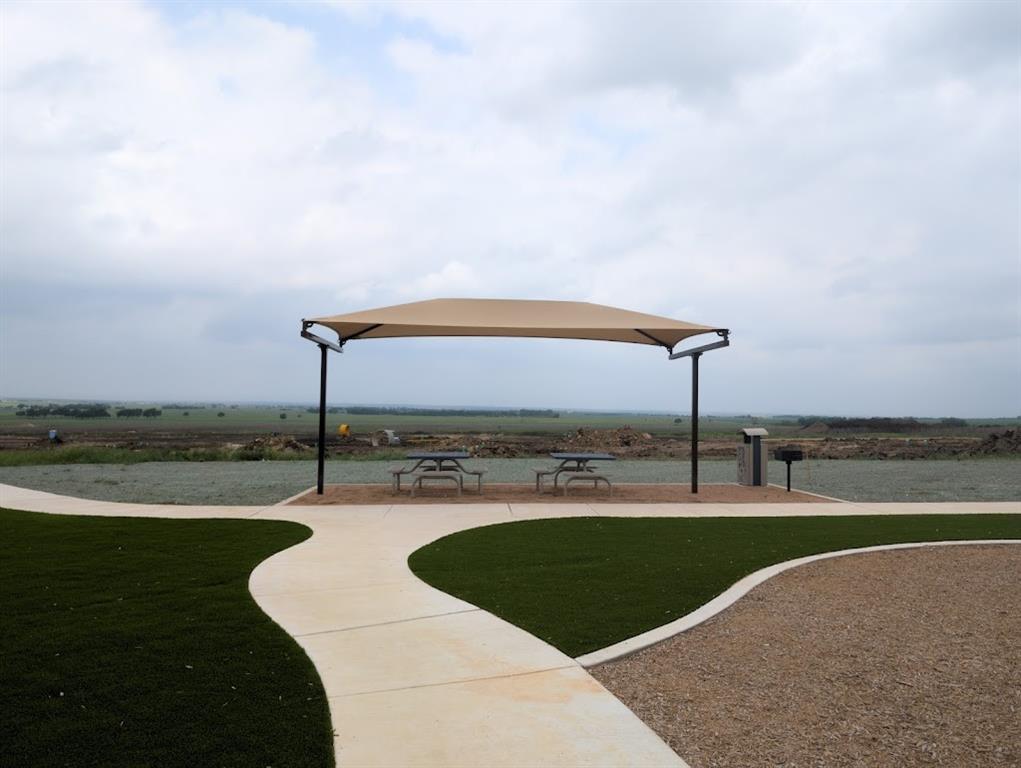 564 Rancho Del Cielo Loop Jarrell, TX 76537 - Photo 12 of 14 An inviting picnic area with a shaded canopy offers tranquil outdoor leisure amidst expansive, open views.