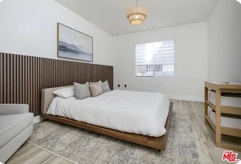 a bed sitting in a bedroom next to a window