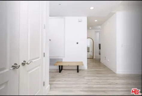 a view of a hallway with wooden floor and closet