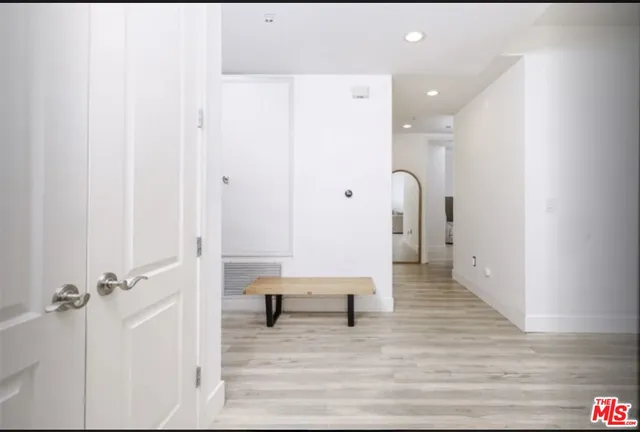 a view of a hallway with wooden floor and closet