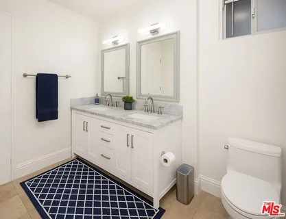 a bathroom with a toilet a sink a vanity and mirror