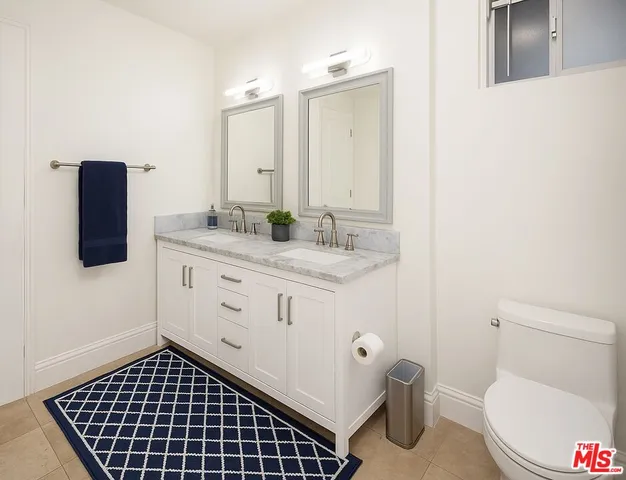 a bathroom with a toilet a sink a vanity and mirror