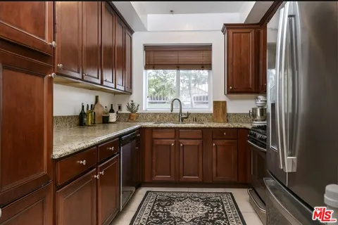a kitchen with stainless steel appliances granite countertop a sink stove and cabinets
