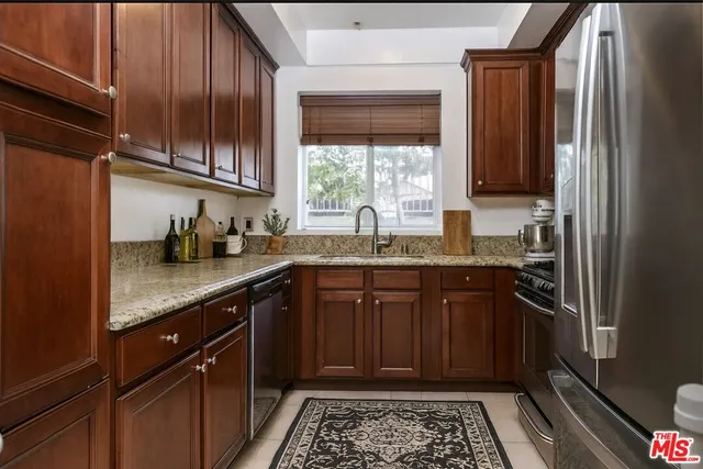 a kitchen with stainless steel appliances granite countertop a sink stove and cabinets