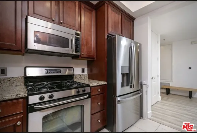 a kitchen with stainless steel appliances granite countertop a refrigerator stove and microwave