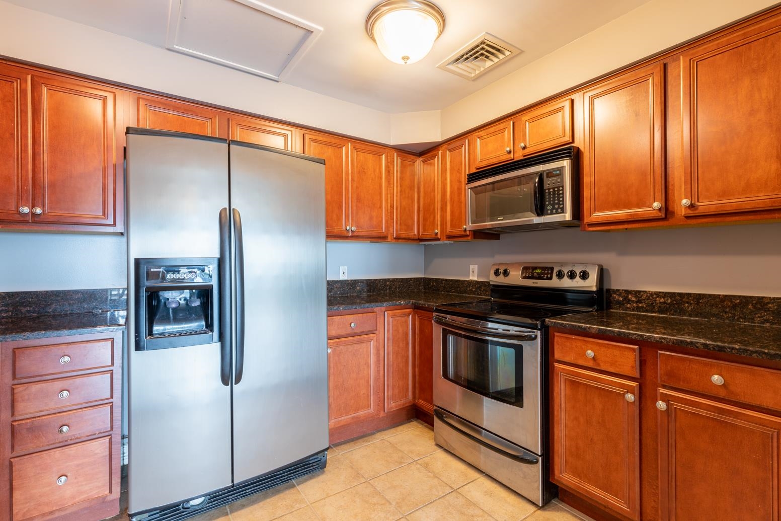 655 Riverside Drive, Unit 406B Memphis, TN 38103 - Photo 11 of 24 a kitchen with granite countertop stainless steel appliances and wooden cabinets
