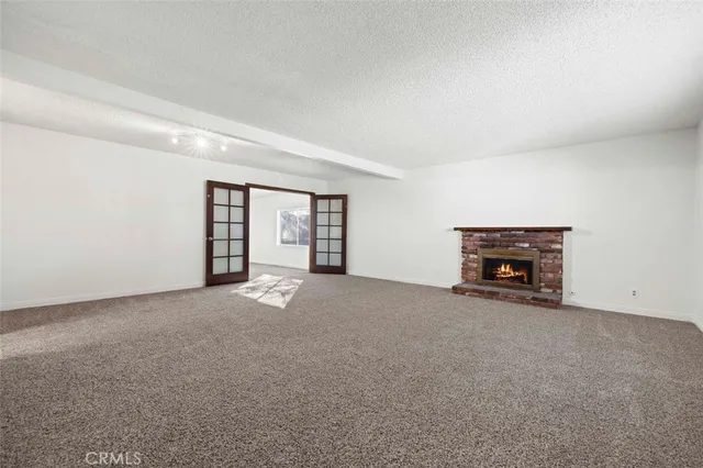 a view of an empty room with a fireplace and a window