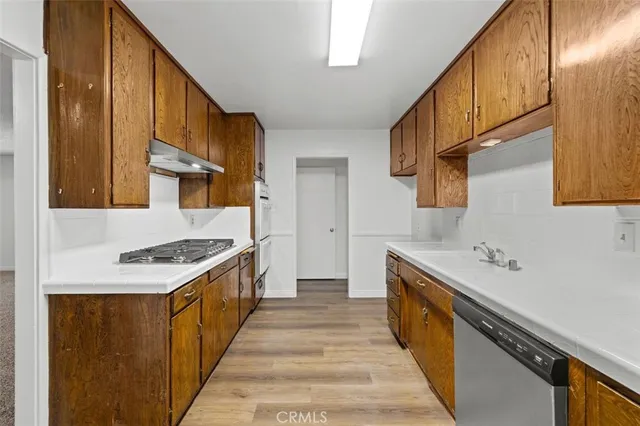 a kitchen with stainless steel appliances a sink stove top oven and cabinets