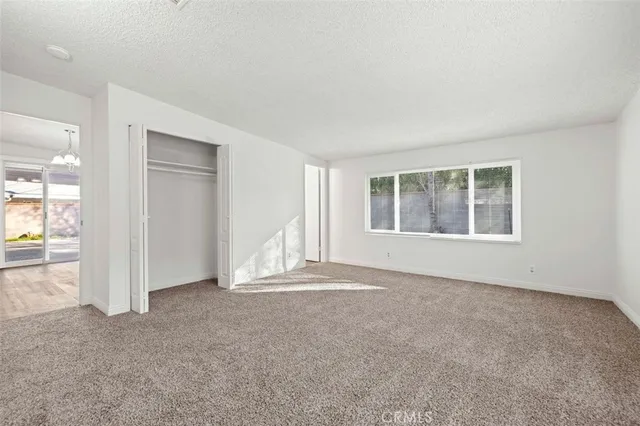 an empty room with a fireplace and large window