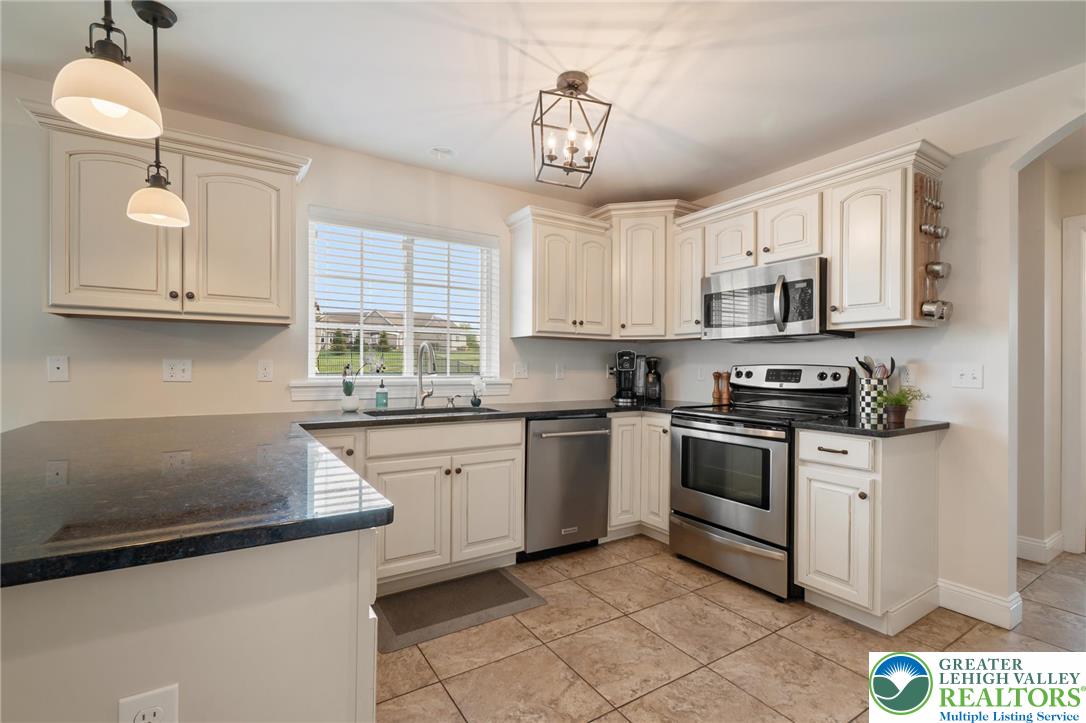 208 East Dell Road Bath, PA 18014 - Photo 8 of 40 a kitchen with stainless steel appliances granite countertop a sink a stove a microwave a sink and cabinets
