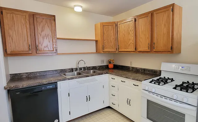 a kitchen with granite countertop cabinets and white appliances