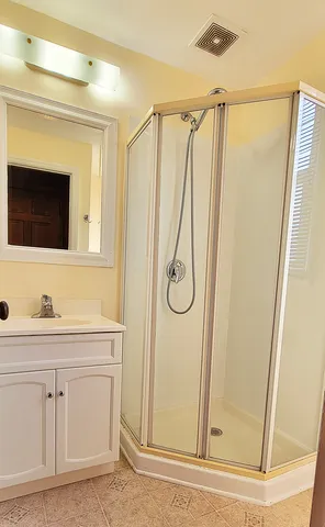 a bathroom with a shower a sink and a mirror