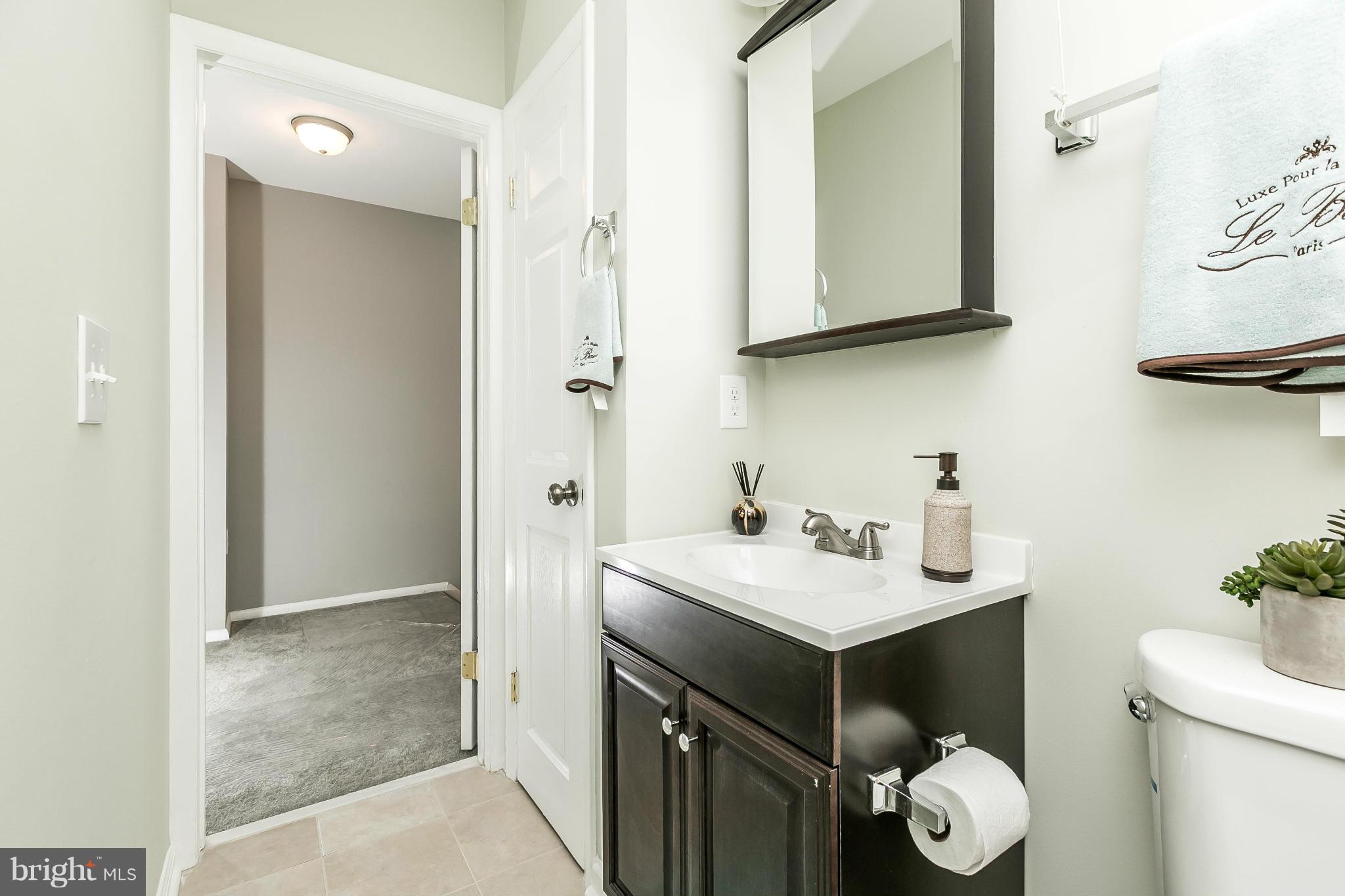 4802 Strathdale Road Baltimore, MD 21206 - Photo 14 of 23 a bathroom with a sink and a mirror