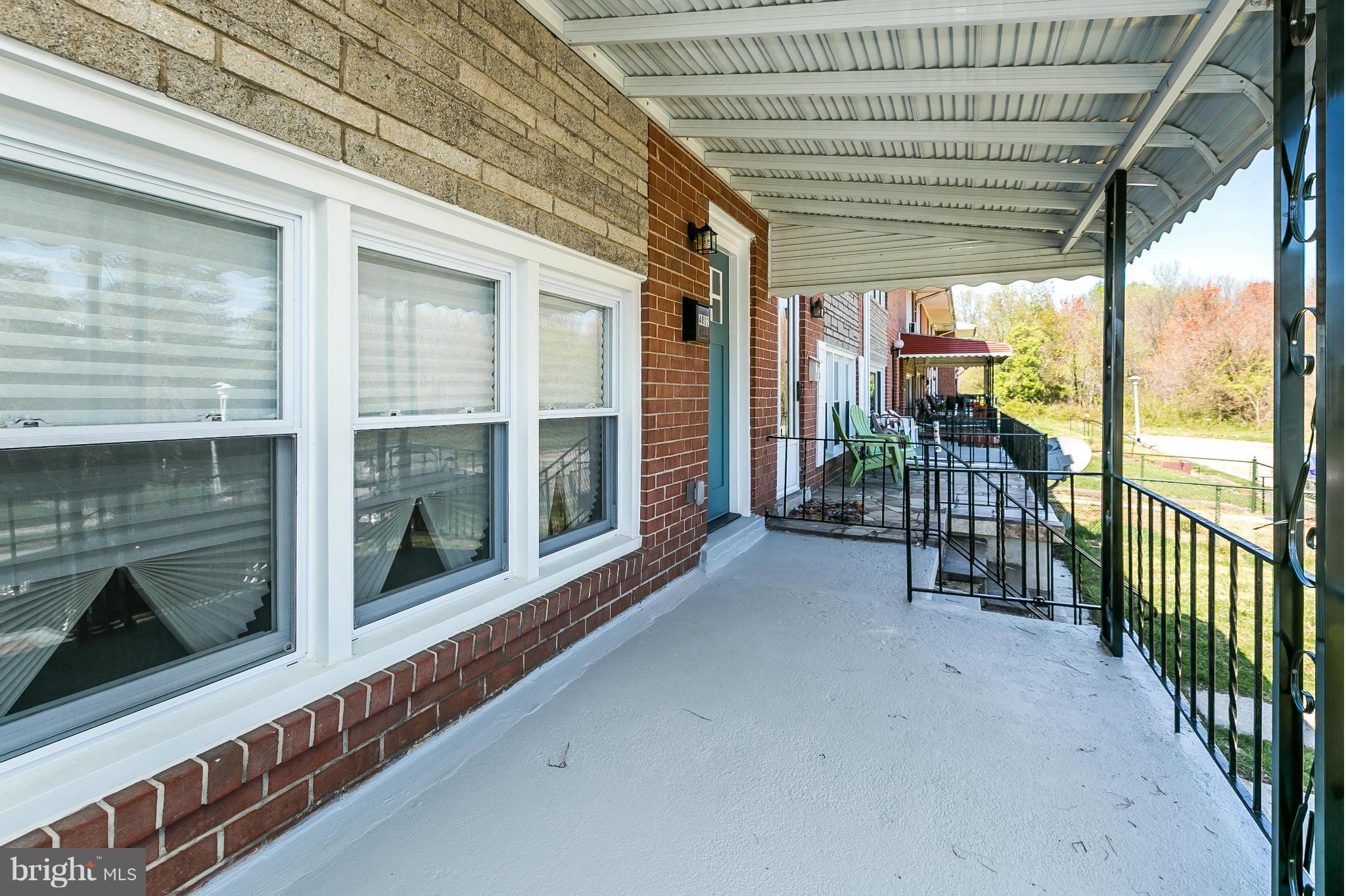 4802 Strathdale Road Baltimore, MD 21206 - Photo 3 of 23 a view of a porch with wooden floor and iron stairs