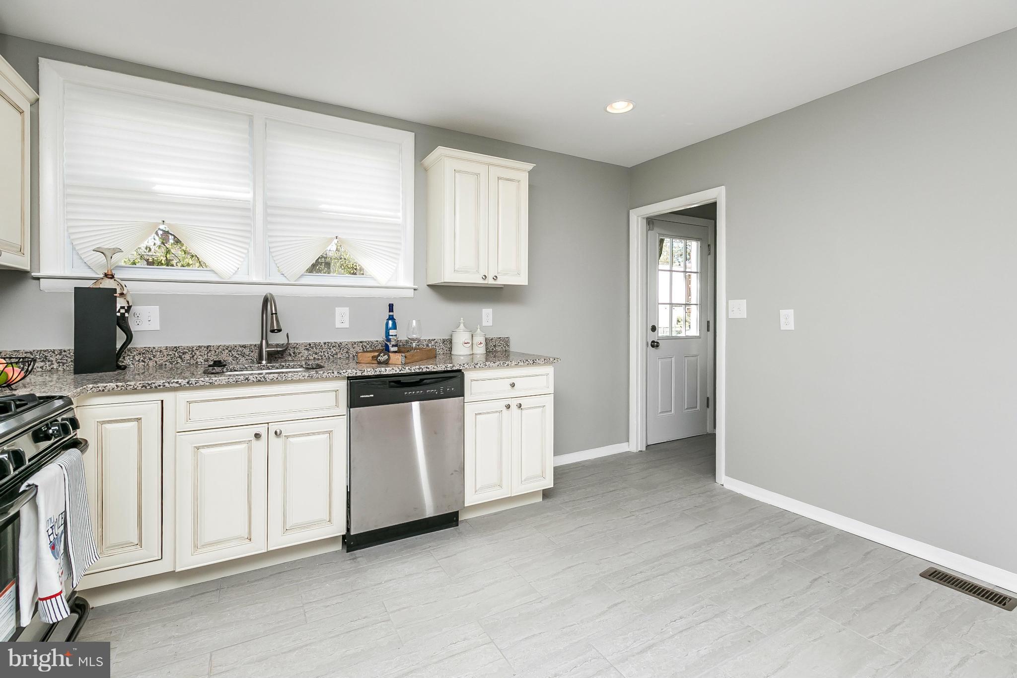 4802 Strathdale Road Baltimore, MD 21206 - Photo 6 of 23 a kitchen with granite countertop white cabinets and white appliances