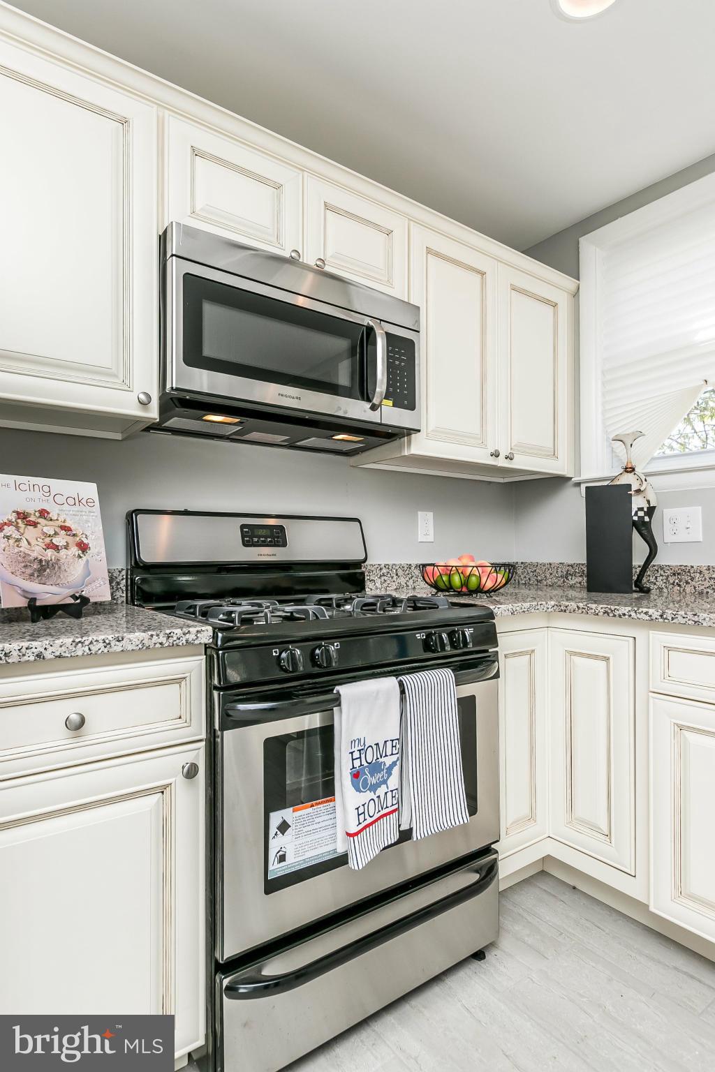 4802 Strathdale Road Baltimore, MD 21206 - Photo 7 of 23 a kitchen with stainless steel appliances granite countertop a stove and a microwave