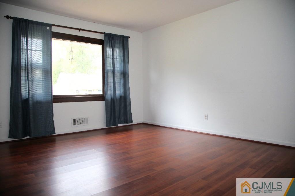47 Caldwell Road Edison, NJ 08817 - Photo 7 of 14 an empty room with wooden floor and windows