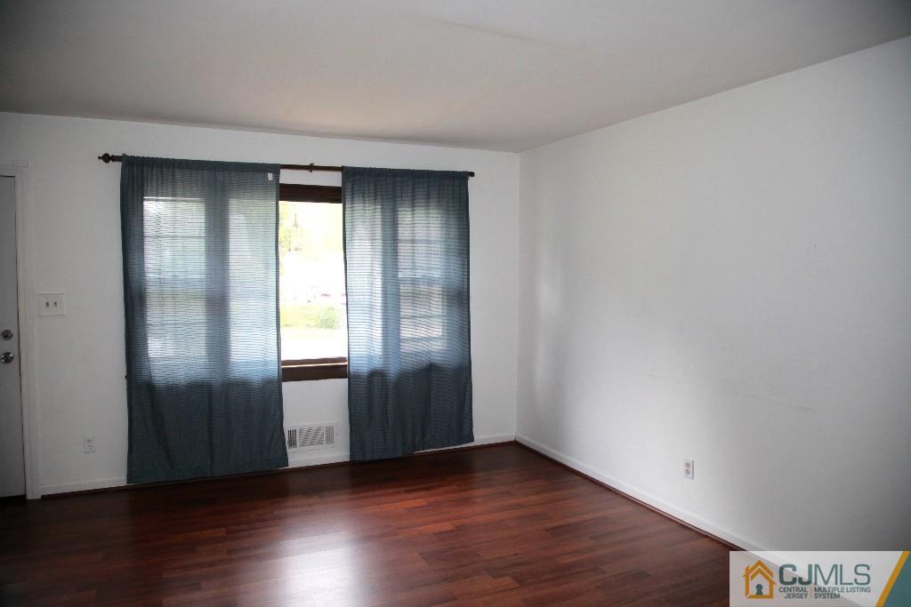 47 Caldwell Road Edison, NJ 08817 - Photo 9 of 14 a view of an empty room with wooden floor and a window