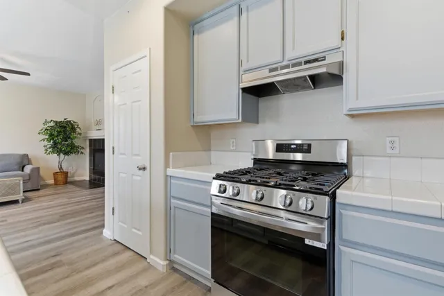 a kitchen with stainless steel appliances granite countertop a stove and a white cabinets