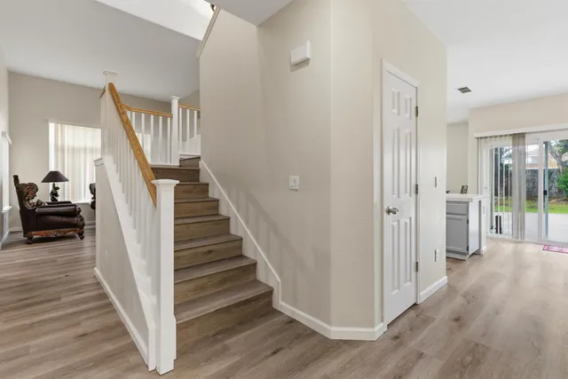 a view of a livingroom with wooden floor and stairs