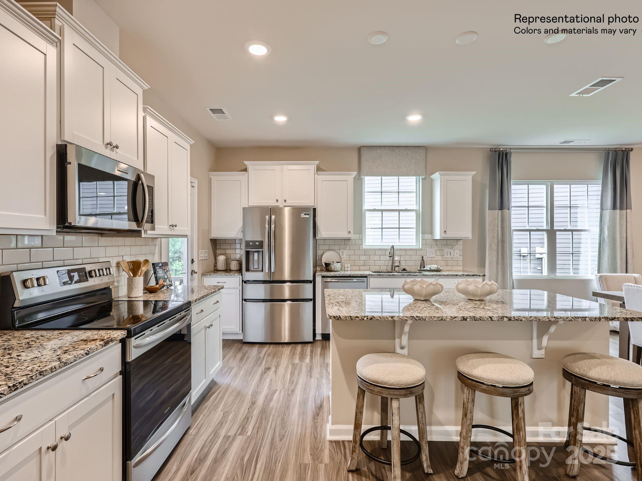 8441 Norman Frst Road Lancaster, SC 29720 - Photo 7 of 20 a kitchen with stainless steel appliances a stove a sink a stove a refrigerator cabinets and dining table