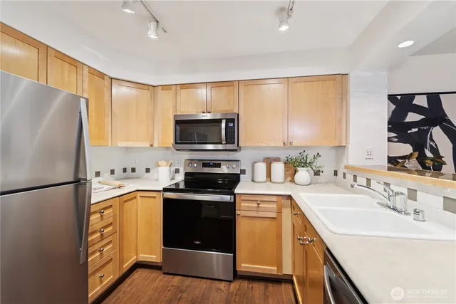 a kitchen with a sink a microwave a refrigerator and cabinets