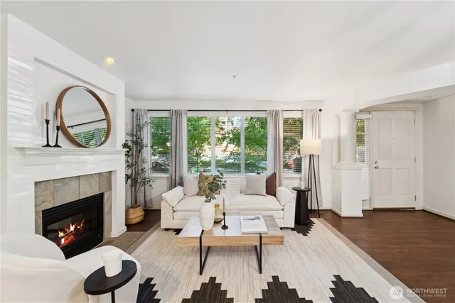 a living room with furniture a fireplace and a large window