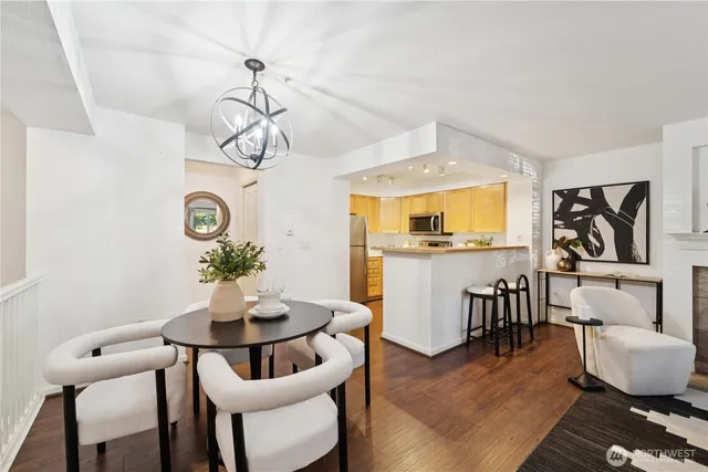 a dining room with wooden floor a chandelier a wooden table and chairs