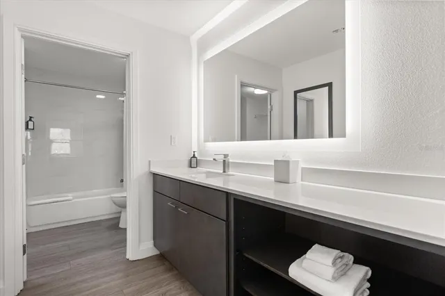 a bedroom with a bed and a lamp on the dresser