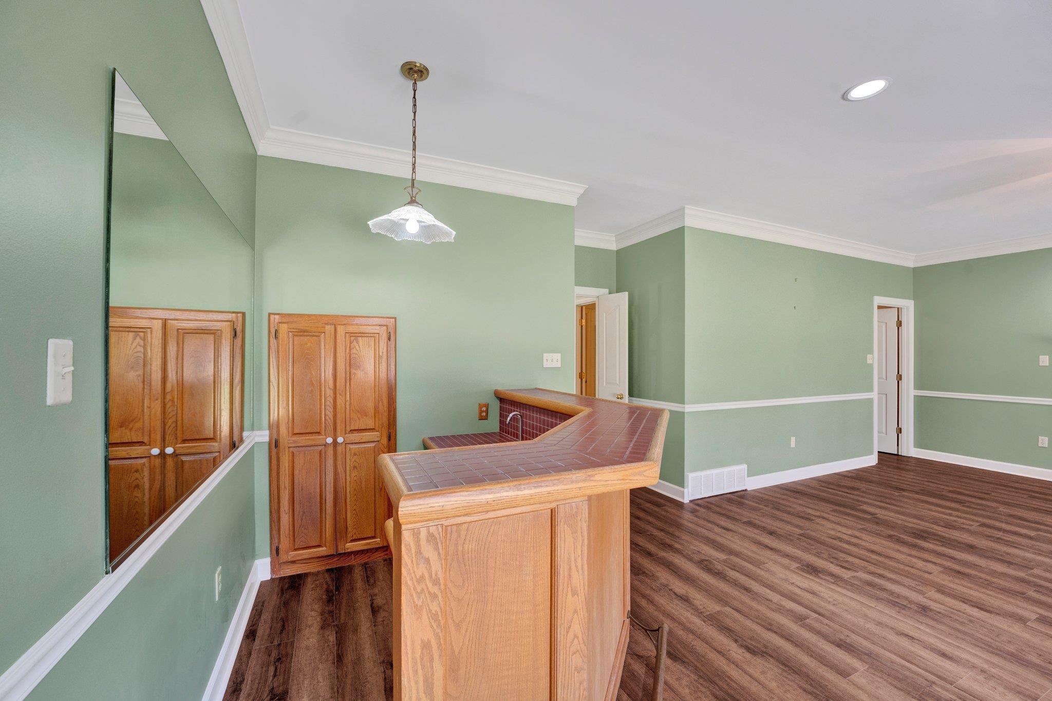 4149 Old Forest Road Memphis, TN 38125 - Photo 15 of 32 Kitchen with decorative light fixtures, ornamental molding, and dark hardwood / wood-style flooring